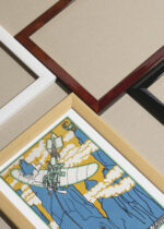 Widok z góry na cztery drewniane ramki, w jednej z nich oprawiony plakat Moriz Jung aeroplan góry Dolomity secesja 1911