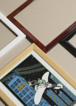 Widok z góry na cztery drewniane ramki, w jednej z nich oprawiony plakat Moriz Jung randka na wieżowcu z samolotem vintage