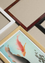 Widok z góry na cztery drewniane ramki, w jednej z nich oprawiony plakat Karpie Koi nishiki-goi Ohara Koson japoński drzeworyt vintage