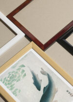 Widok z góry na cztery drewniane ramki, w jednej z nich oprawiony plakat Karpie koi nishiki-goi Ohara Koson japoński monochromatyczny