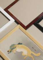 Widok z góry na cztery drewniane ramki, w jednej z nich oprawiony plakat Lis w kapeluszu Ohara Koson japoński humorystyczny