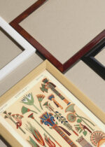 Widok z góry na cztery drewniane ramki, w jednej z nich oprawiony plakat egipski ornament Owen Jones Gramatyka Ornamentu