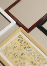 Widok z góry na cztery drewniane ramki, w jednej z nich oprawiony plakat botaniczny Owen Jones Gramatyka Ornamentu 1856