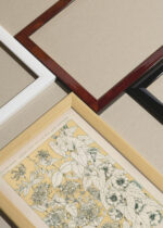 Widok z góry na cztery drewniane ramki, w jednej z nich oprawiony plakat botaniczny kwiaty powojnika Owen Jones 1856