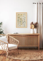 Aranżacja wnętrza, na ścianie wisi plakat w ramce: botaniczny kwiaty powojnika Owen Jones 1856