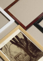 Widok z góry na cztery drewniane ramki, w jednej z nich oprawiony plakat Eugène Atget Świątynia Miłości Pałac Wersalski Paryż