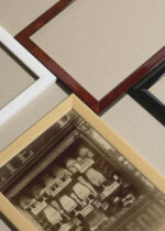 Widok z góry na cztery drewniane ramki, w jednej z nich oprawiony plakat Atget witryna sklepu medycznego Paryż 1923 vintage