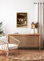 Aranżacja wnętrza, na ścianie wisi plakat w ramce: E. Atget witryna salonu fryzjerskiego Paryż 1912