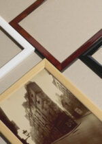 Widok z góry na cztery drewniane ramki, w jednej z nich oprawiony plakat Paryż 1908 Belle Époque Eugène Atget zdjęcie vintage