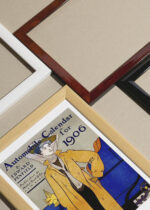 Widok z góry na cztery drewniane ramki, w jednej z nich oprawiony plakat Automobile calendar for 1906
