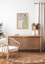 Aranżacja wnętrza, na ścianie wisi plakat w ramce: Kobieta w zielonej sukni czytająca książkę (1895)