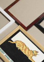 Widok z góry na cztery drewniane ramki, w jednej z nich oprawiony plakat Merry Xmas (1921) świąteczny vintage