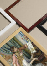 Widok z góry na cztery drewniane ramki, w jednej z nich oprawiony plakat Renoir Dwoje młodych dziewcząt przy pianinie 1892