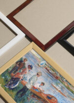 Widok z góry na cztery drewniane ramki, w jednej z nich oprawiony plakat Renoir Wioślarze w Chatou 1879 impresjonizm