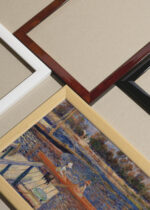 Widok z góry na cztery drewniane ramki, w jednej z nich oprawiony plakat Renoir Sekwana w Argenteuil łodzie na rzece