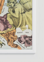 Zbliżenie na detale plakatu oprawionego w drewnianą białą ramkę od Plakatello®: satyryczna mapa Europy 1870 vintage antyczna