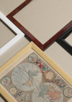 Widok z góry na cztery drewniane ramki, w jednej z nich oprawiony plakat Mapa Świata vintage XVIII wiek barokowa kartografia