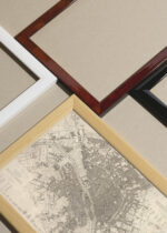 Widok z góry na cztery drewniane ramki, w jednej z nich oprawiony plakat historyczna mapa Paryża XIX wiek sepia vintage