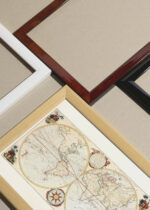 Widok z góry na cztery drewniane ramki, w jednej z nich oprawiony plakat mapa świata XVIII wiek dwie półkule retro