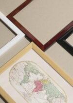 Widok z góry na cztery drewniane ramki, w jednej z nich oprawiony plakat stara mapa świata XVIII wiek francuska kartografia