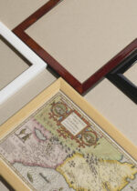 Widok z góry na cztery drewniane ramki, w jednej z nich oprawiony plakat historyczna mapa Wirginii i Florydy USA XVI wiek