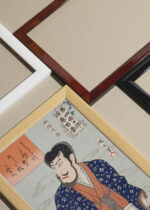 Widok z góry na cztery drewniane ramki, w jednej z nich oprawiony plakat japoński aktor kabuki Tokio 1890 Toyohara Kunichika