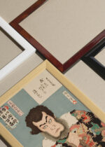 Widok z góry na cztery drewniane ramki, w jednej z nich oprawiony plakat aktor orientalny drzeworyt Toyohara Kunichika ukiyo-e